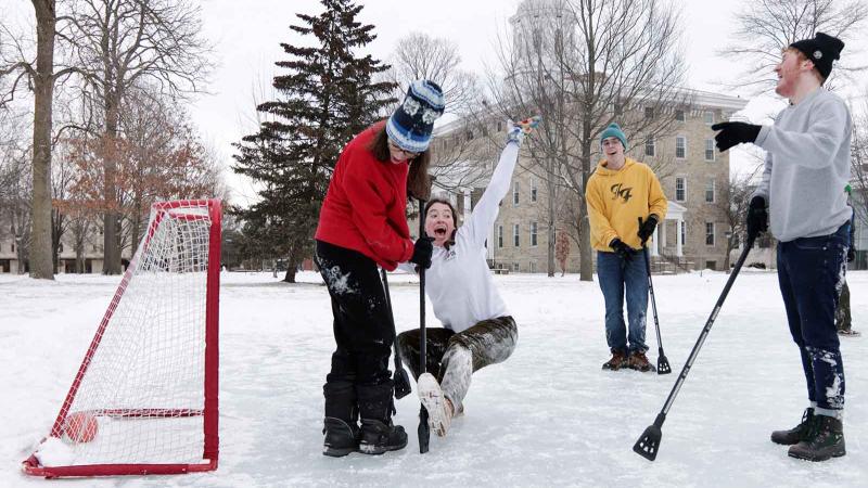 Maddy Tevonian, a sophomore, falls down as she celebrates after scoring the game-winning goal during broomball on Ormsby Lake during Winter Carnival.