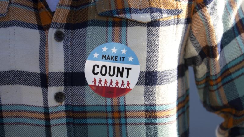 A Make It Count voter sticker is seen on the shirt of a Lawrence student.