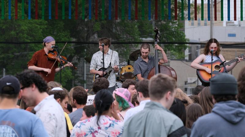 Four members of The Woebegones perform during the 2022 LUaroo festival on Main Hall Green as students cheer them on.