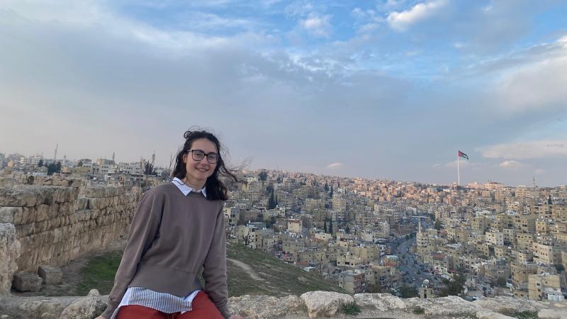 Sela Dombrower poses for a photo with the landscape of Jordan in the background.