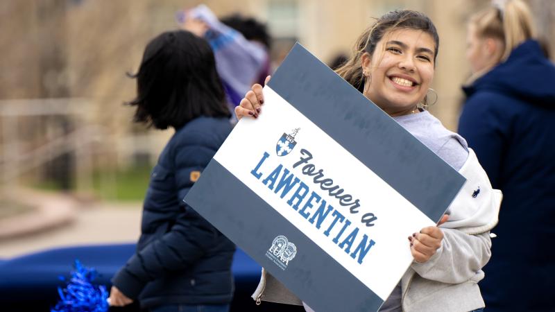 Sophomore Bruna Velez holds a Forever a Lawrentian sign as games are held on campus to win prizes. 
