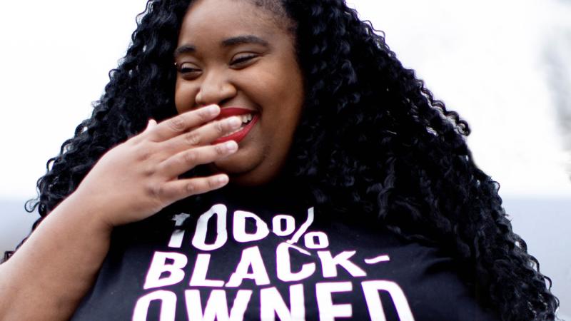 Brienne Colston laughing and in a 100% Black-Owned tshirt