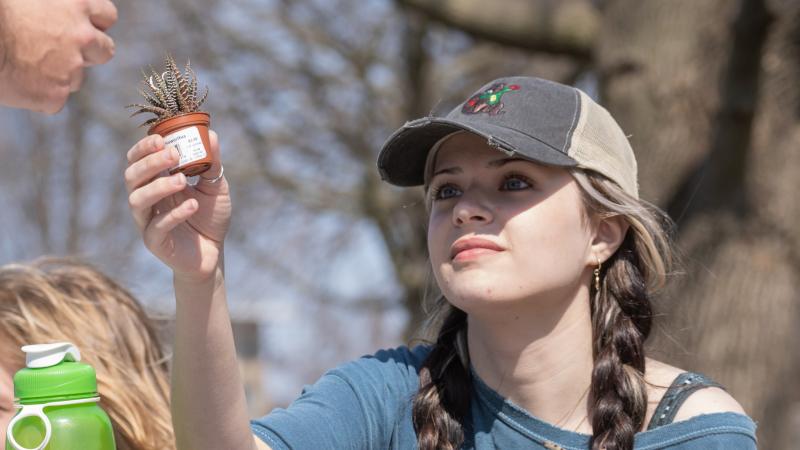 A student sells plants at the 2022 Earthfest.