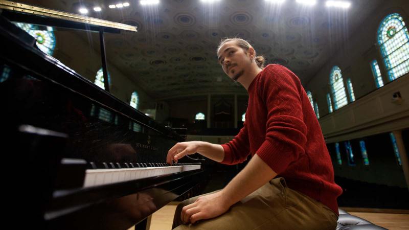 Student, Bohdan Tataryn, from Ukraine plays piano in Memorial Chapel