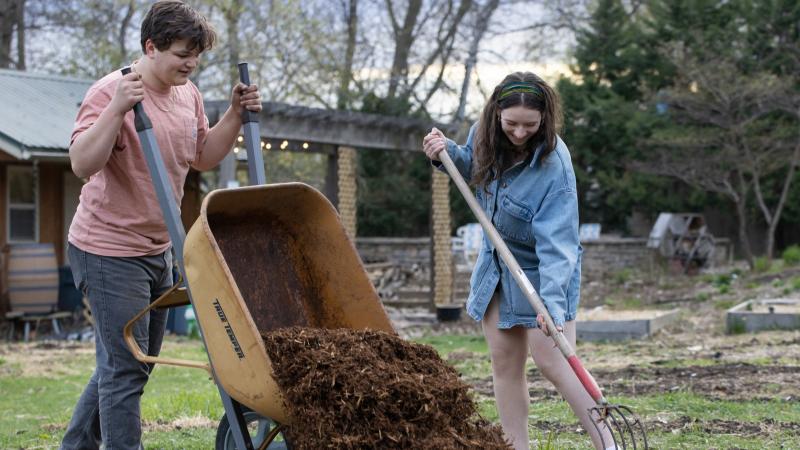 Anders Hanhan and another student spread mulch in SLUG. 