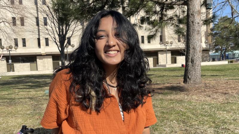 Tee Karki '23 sits on the lawn on campus.