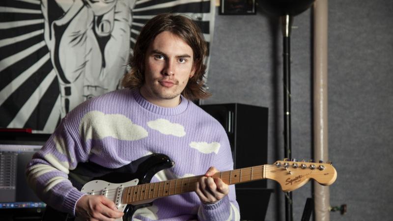 Michael Murphy poses for a photo with his guitar in SOL Studios.