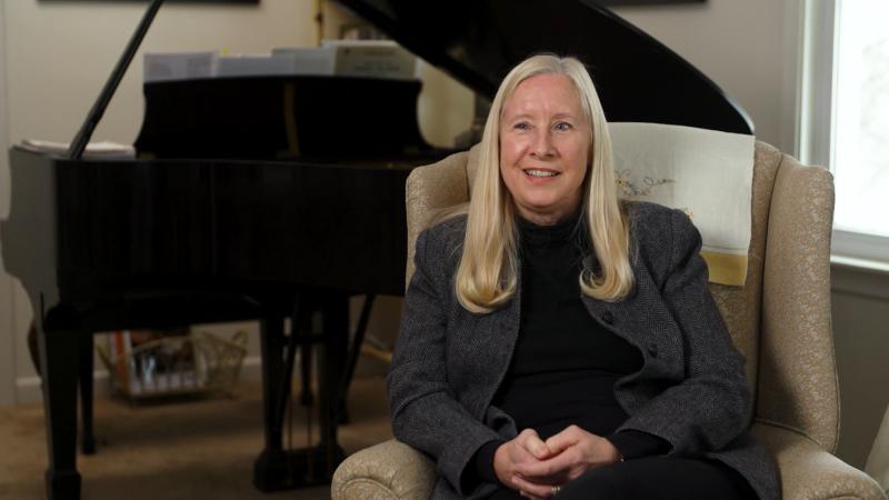 Martha Helen Schmidt sits in front of a piano.