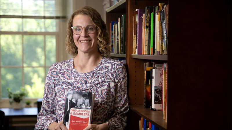 Betsy Schlabach holds a copy of her book, Dream Books and Gamblers