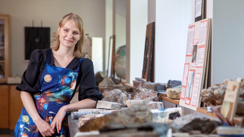 Sydney Closson poses amid a collection of rocks in Youngchild Hall.