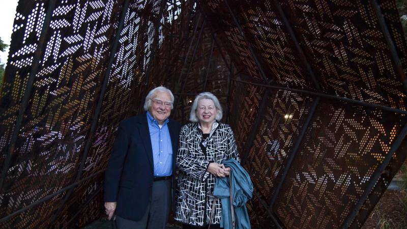 Robert and Patricia Anker stand for a portrait inside the new sculpture on campus in 2021.