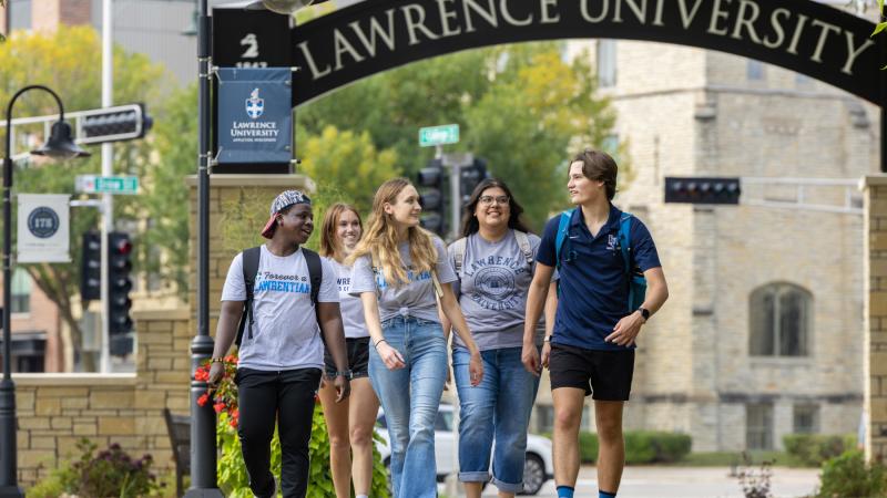 Five Lawrence students walk beneath the Lawrence Arch.