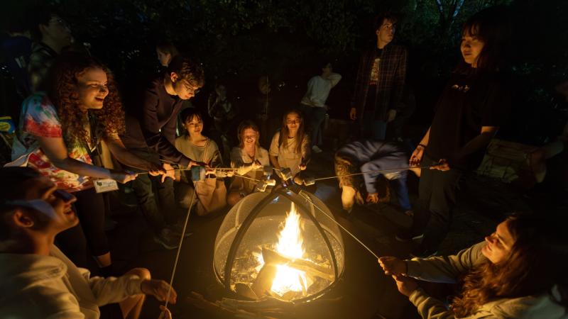Students make s'mores at a bonfire in SLUG.