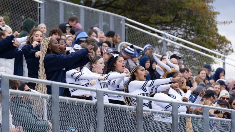 The cheer team leads cheers in the stands at Banta Bowl during the Homecoming football game.