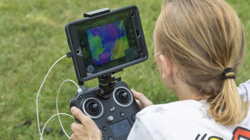 Student evaluating weather on drone remote control