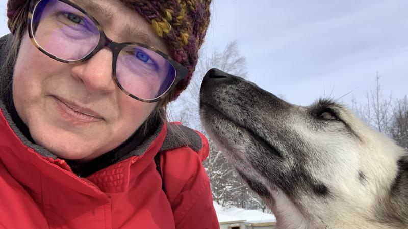 Kate Newmyer gets a kiss on the cheek from a sled dog.