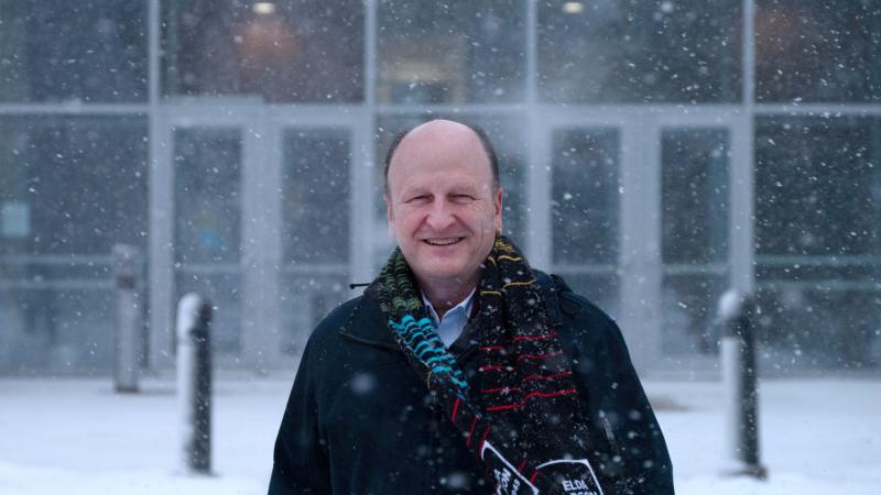 Matthew Stoneking poses for a portrait in front of Youngchild Hall as the snow comes down.