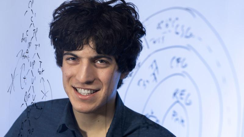 Eitan Price is pictured with linguistics computations behind him.