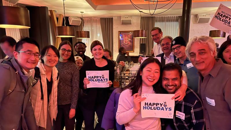 Lawrence alumni hold Happy HoLUdays signs at a gathering in San Francisco.