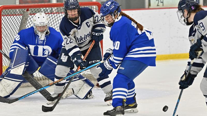 Seniors Lauren Askenazy (22) and Delaney Kingsland (9) compete for the puck against the University of Dubuque.