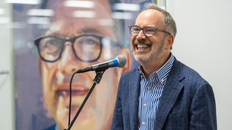 Former President Mark Burstein speaks in front of his presidential portrait in the Center for Academic Success in Mudd Library.