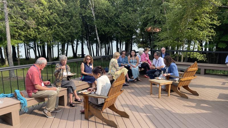 a group of people eat outside on a deck