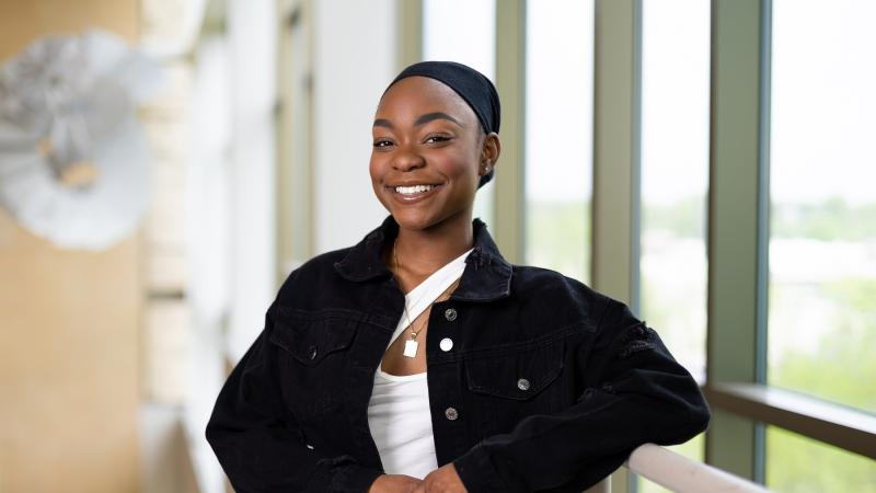 Monique Johnson poses for a portrait in front of the large windows in Warch Campus Center.