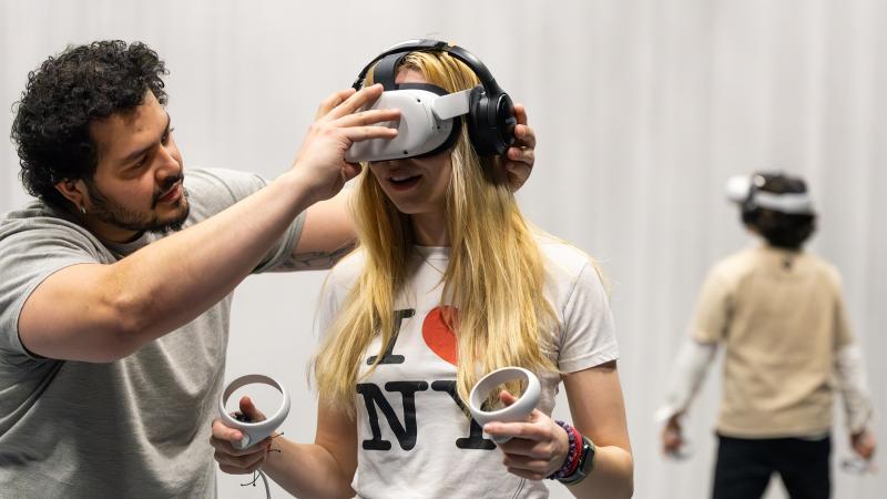 Jose Lozano works with Annika Urness, a sophomore, to set up a virtual reality multiplayer game.