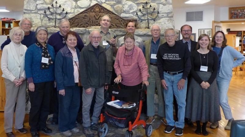 seminar guests pose in front of a stone fireplace