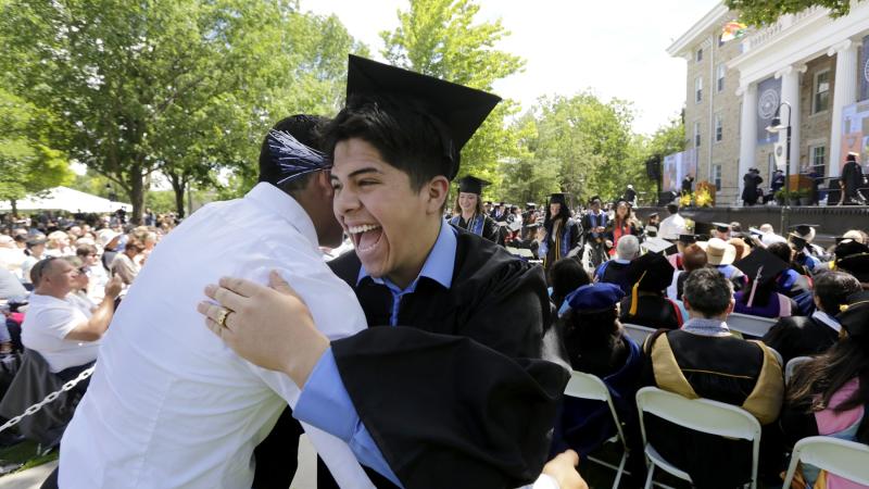 A graduate gets a hug at Commencement.