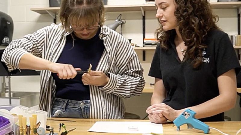 Student making a reed for an oboe or bassoon in reed maiking workshop with faculty