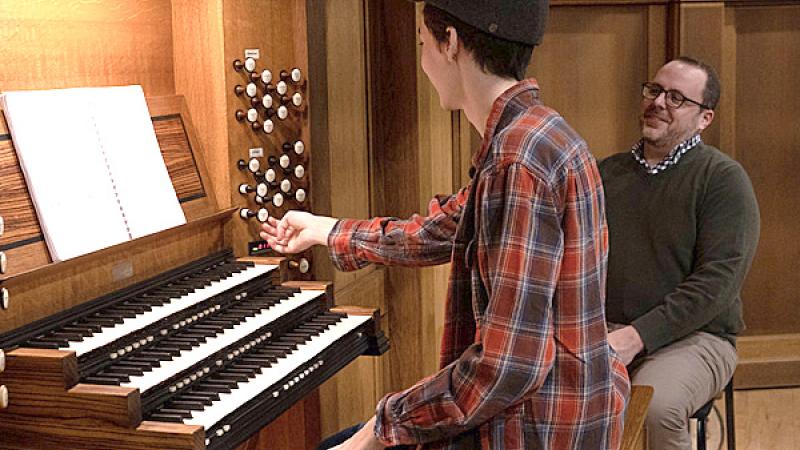 Student playing organ in Memorial Chapel while instructor looks on