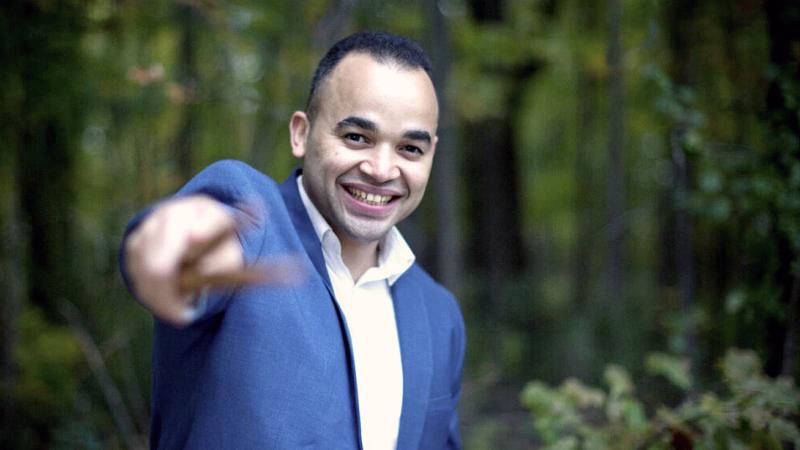 Jean Carlo Ureña Gonzalez standing in woods and pointing at viewer with drum sticks