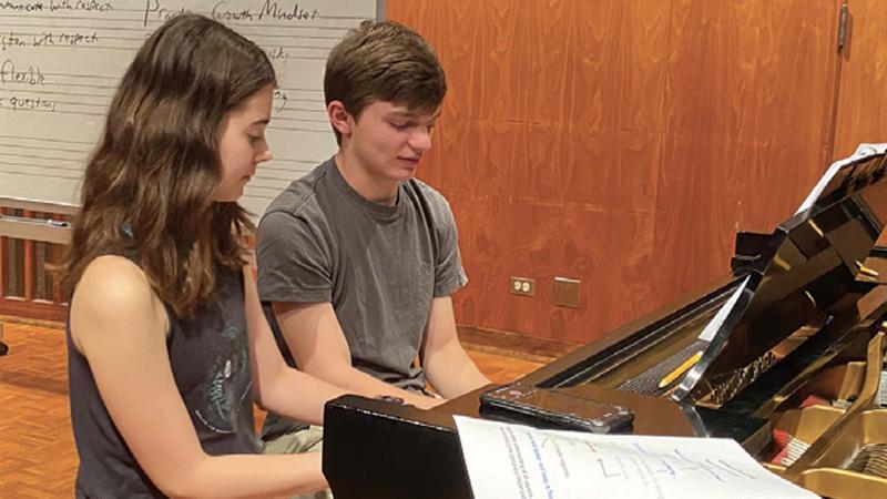 Two students practicing piano in Harper Hall