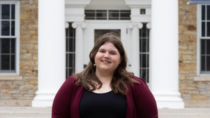 Brooklyn Schara poses for a photo in front of Main Hall.
