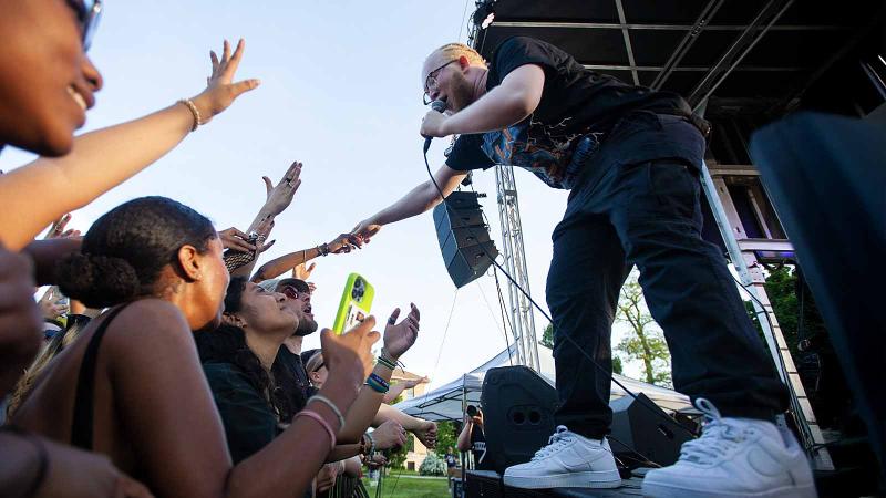 NOIR performs at LUaroo with lead singer reaching out to students at edge of stage.