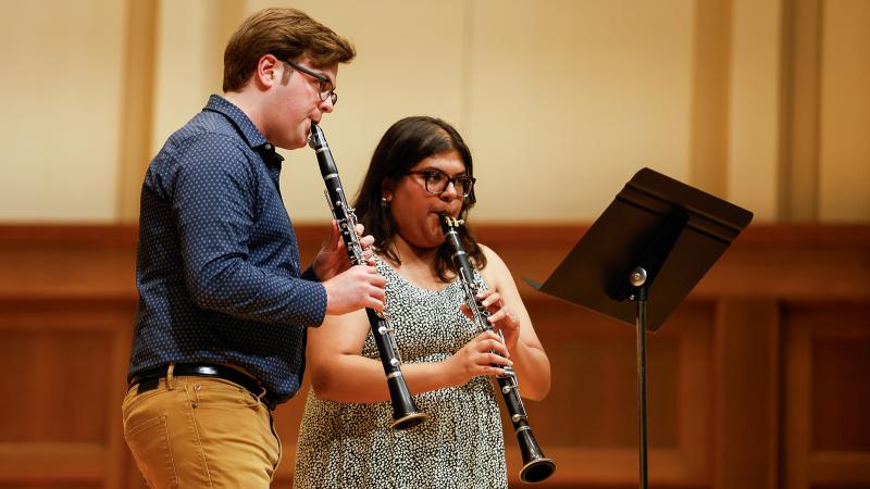 A duo of musicians playing clarinets.