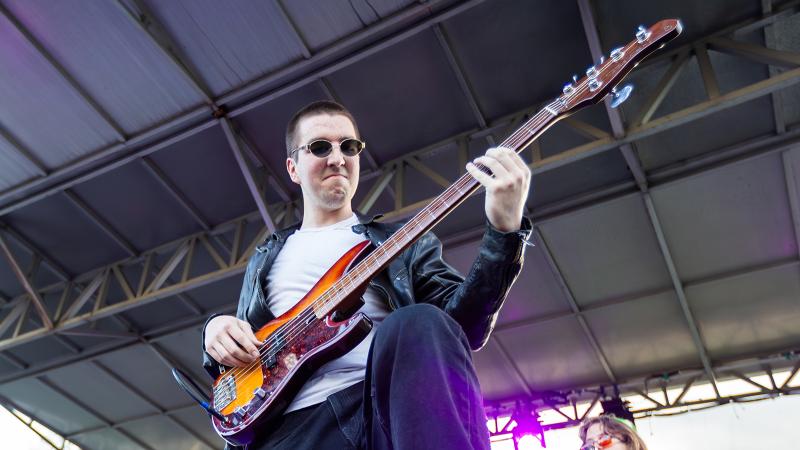 A rock musician playing electric bass at LUaroo.