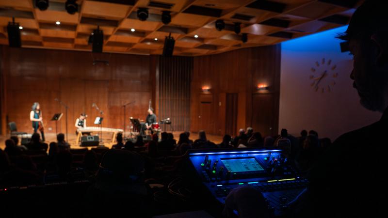 Silhouetted audio engineer at Front-of-House mixer during a concert in Harper Hall.