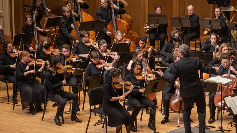 A large orchestra led by a conductor.