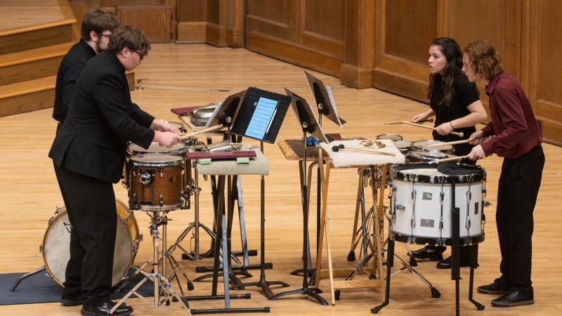 A quartet of musicians playing various percussion instruments.