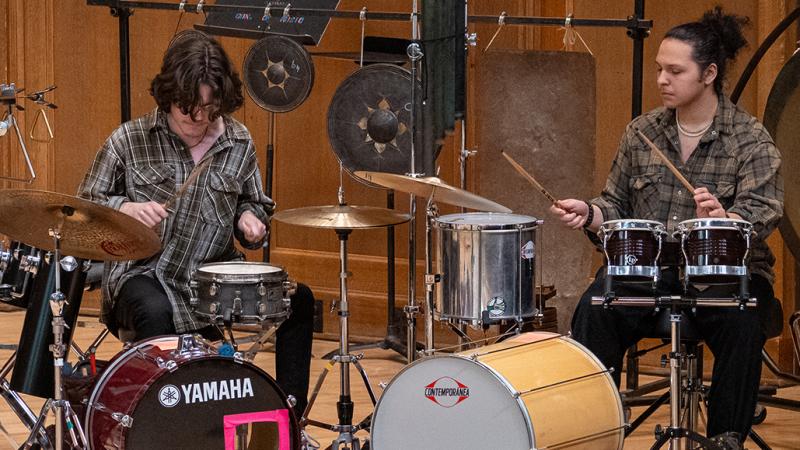 A pair of musicians playing on various percussion instruments.