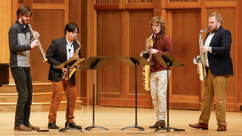 A quartet of saxophonists performing on stage.