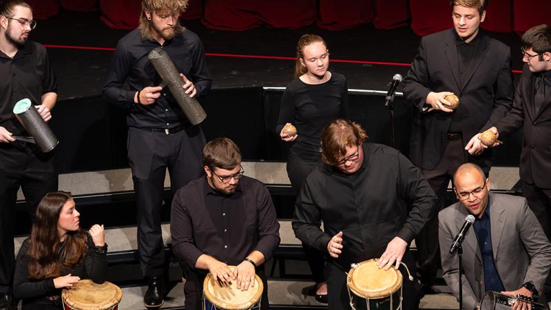A small ensemble of musicians playing percussion instruments from the Dominican Republic.
