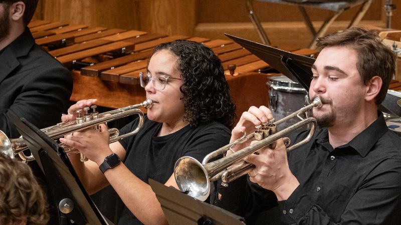 Two musicians playing trumpets in the Wind Ensemble.