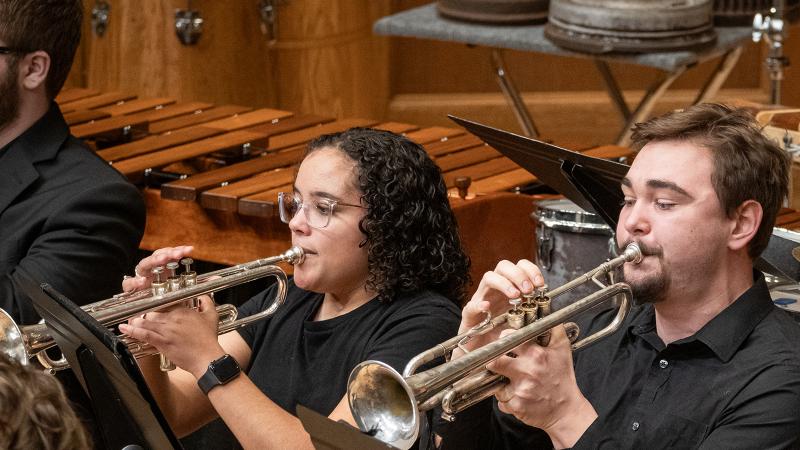 Two musicians playing trumpets in the Wind Ensemble.