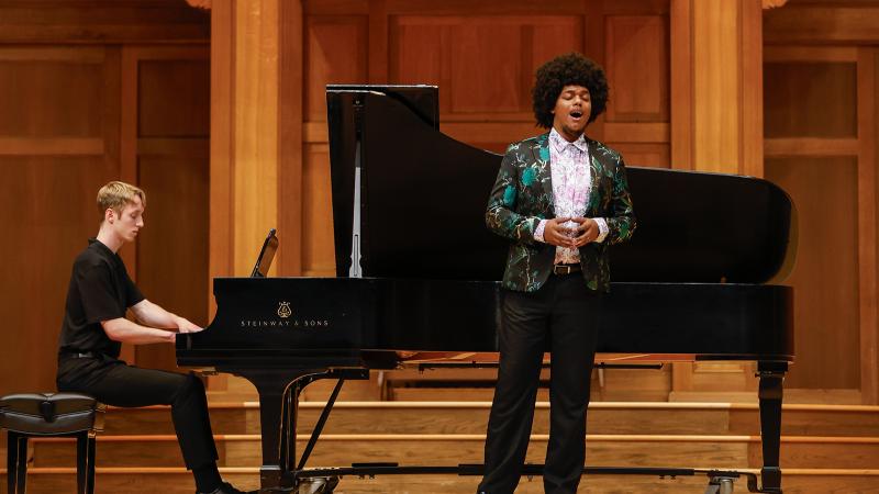 A vocalist and pianist in performance on stage.