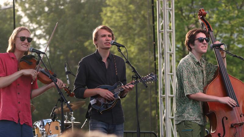 A trio of bluegrass musicians playing fiddle, mandolin, and upright bass.