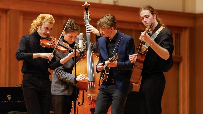 A quartet of bluegrass musicians playing string instruments.