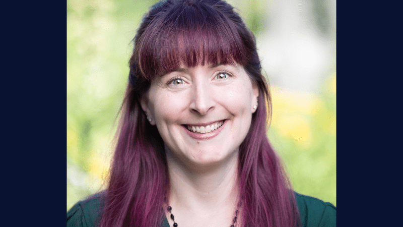 A person with purple hair and smiling